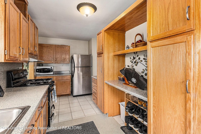 kitchen featuring brown cabinetry, stainless steel appliances, open shelves, under cabinet range hood, and a sink
