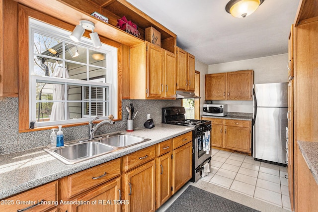 kitchen with tasteful backsplash, stainless steel appliances, under cabinet range hood, and a sink