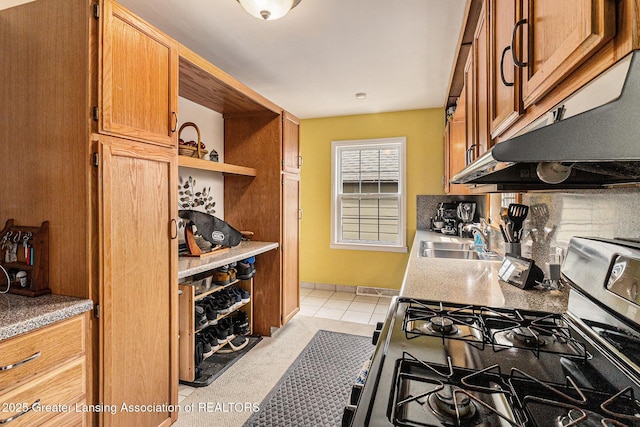 kitchen featuring a sink, under cabinet range hood, light tile patterned floors, open shelves, and stainless steel gas stove