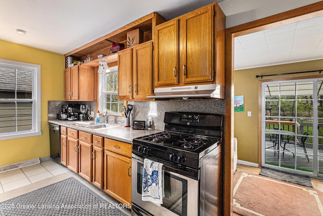 kitchen with decorative backsplash, a sink, under cabinet range hood, stainless steel gas range oven, and black dishwasher