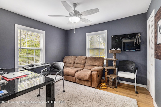 office space with a ceiling fan, wood finished floors, and baseboards