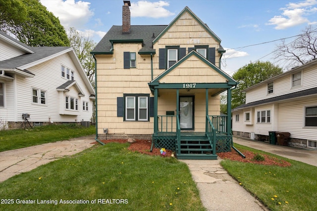 bungalow with a porch, a chimney, central air condition unit, a front lawn, and a shingled roof