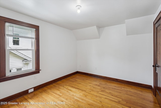 additional living space with light wood-style floors and baseboards