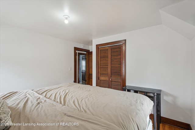 bedroom featuring baseboards, a closet, and wood finished floors