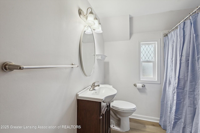 bathroom with vanity, baseboards, wood finished floors, and toilet