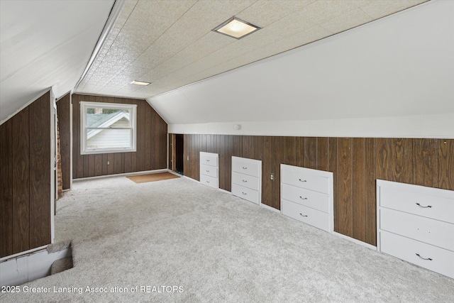 bonus room featuring wooden walls, vaulted ceiling, and carpet floors