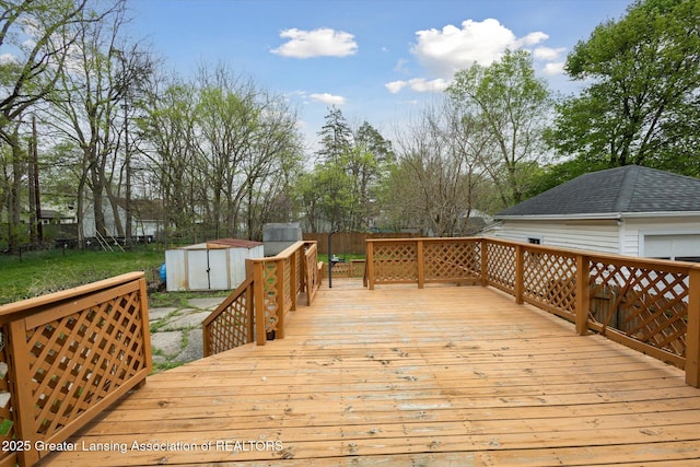 wooden terrace featuring a storage shed and an outbuilding