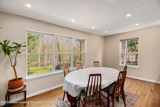 dining area with baseboards, wood finished floors, and recessed lighting