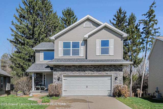 view of front of house with stone siding, a front lawn, a garage, and concrete driveway