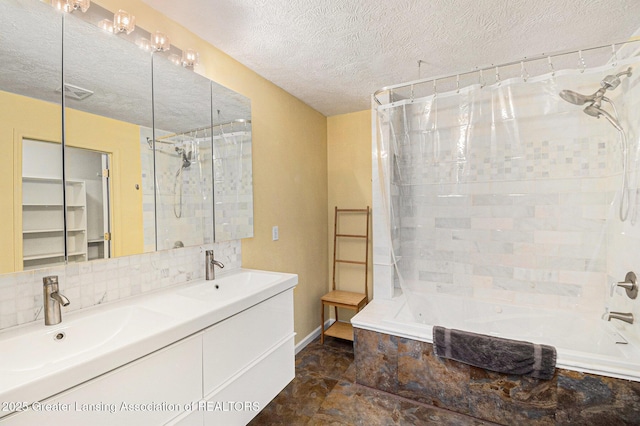 full bathroom featuring a textured ceiling, tasteful backsplash, tiled shower / bath combo, and a sink