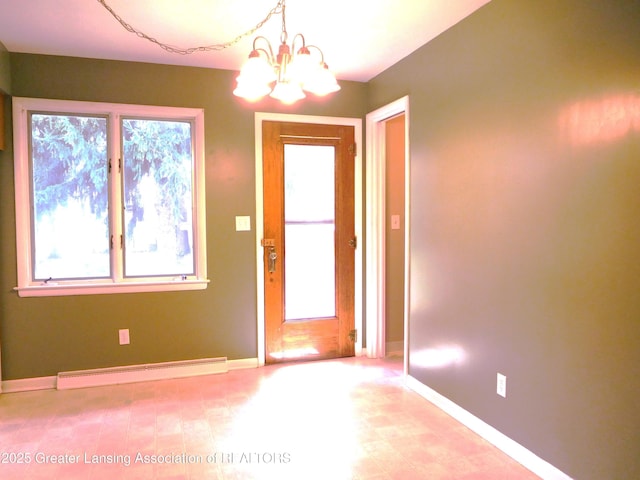 spare room featuring baseboards, an inviting chandelier, plenty of natural light, and a baseboard radiator
