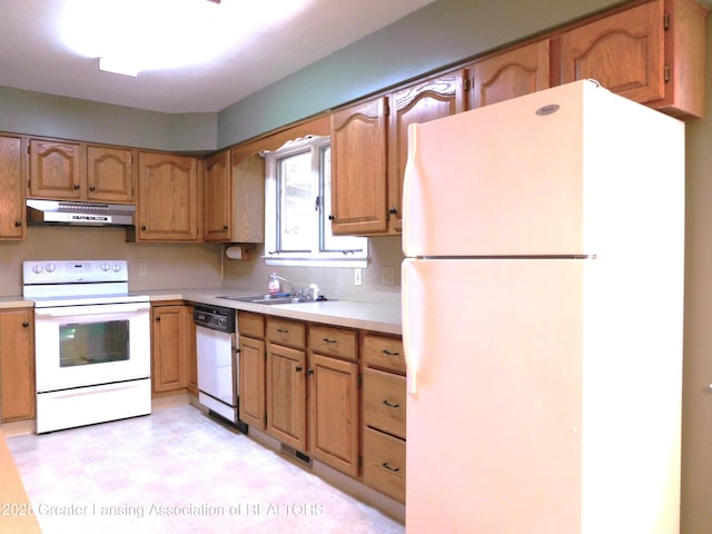 kitchen with a sink, white appliances, light floors, light countertops, and under cabinet range hood