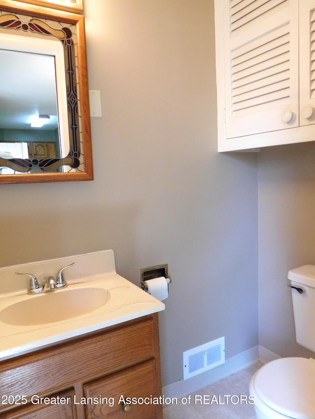 bathroom featuring visible vents, baseboards, toilet, vanity, and tile patterned flooring