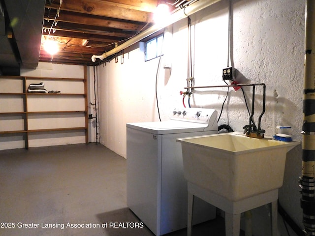 clothes washing area with washer and clothes dryer, laundry area, and a sink