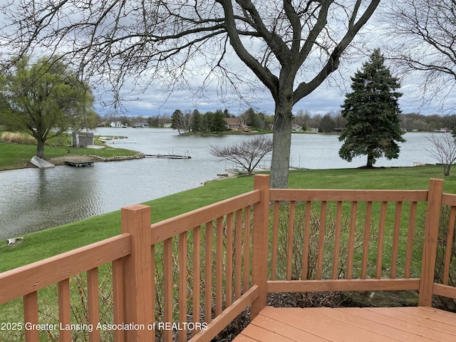 wooden terrace with a lawn and a water view