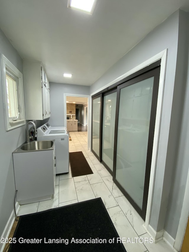 laundry room with separate washer and dryer, cabinet space, marble finish floor, a sink, and baseboards