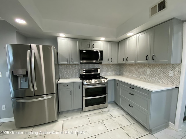 kitchen with visible vents, gray cabinetry, stainless steel appliances, light countertops, and marble finish floor
