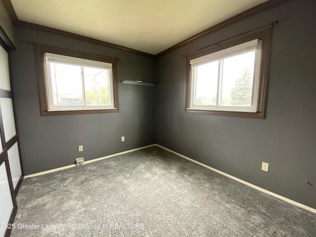 carpeted empty room with ornamental molding and baseboards