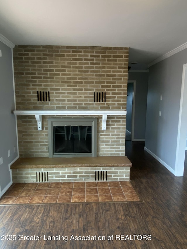room details with a fireplace, wood finished floors, crown molding, and baseboards