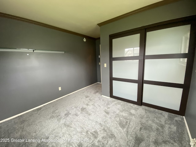 unfurnished room featuring crown molding, carpet, and baseboards