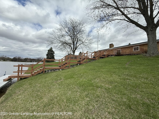 view of yard with a deck with water view