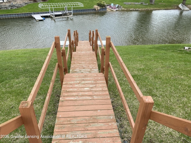 view of dock featuring a yard and a water view
