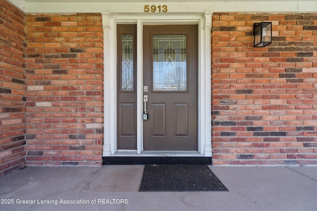doorway to property featuring brick siding