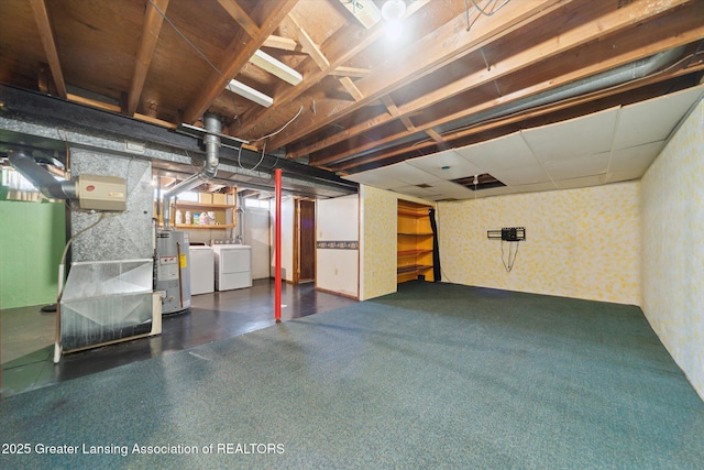 unfinished basement with water heater, washing machine and dryer, and wallpapered walls