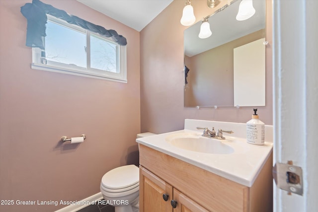 bathroom featuring toilet, baseboards, and vanity