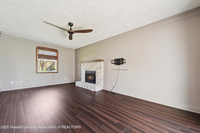 unfurnished living room featuring baseboards, a ceiling fan, dark wood finished floors, and a textured ceiling