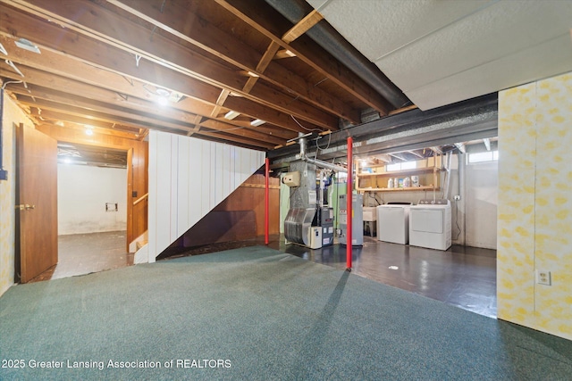 basement with heating unit, washing machine and dryer, and gas water heater