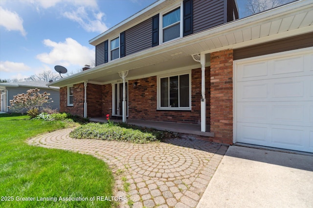 property entrance featuring brick siding, a garage, covered porch, and driveway