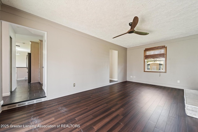 spare room with baseboards, ceiling fan, a textured ceiling, and wood finished floors