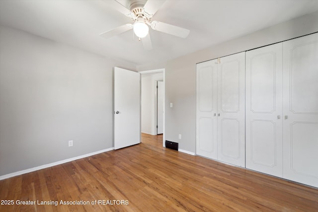 unfurnished bedroom with light wood-style floors, baseboards, a ceiling fan, and a closet
