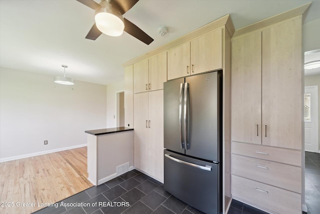 kitchen featuring light brown cabinets, freestanding refrigerator, a ceiling fan, a peninsula, and visible vents