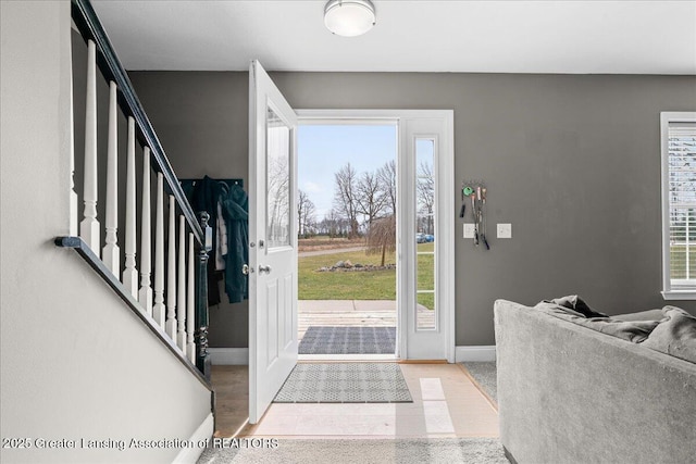 entryway with baseboards and stairway