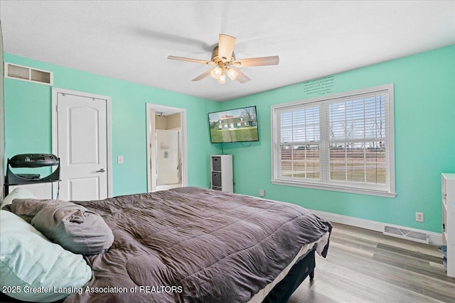 bedroom featuring ceiling fan, baseboards, wood finished floors, and visible vents