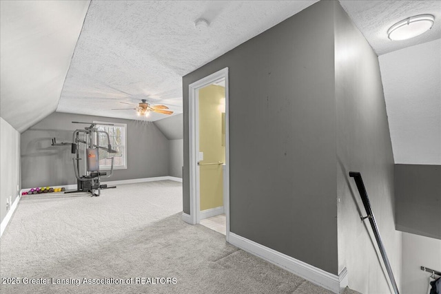 additional living space with vaulted ceiling, baseboards, a textured ceiling, and carpet floors