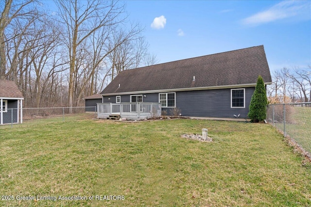 back of property featuring a deck, a shingled roof, a fenced backyard, a yard, and a garage