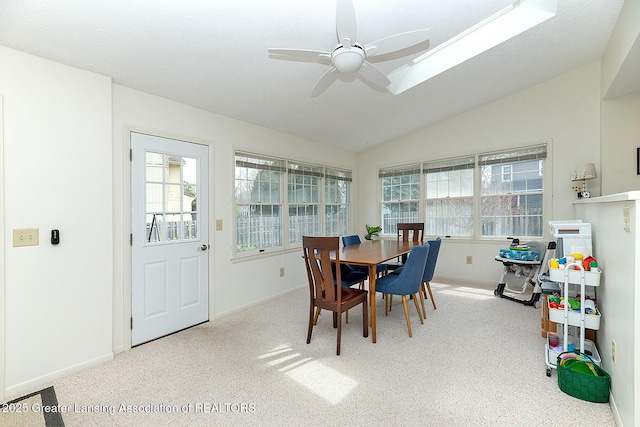 carpeted dining room with baseboards, ceiling fan, and lofted ceiling