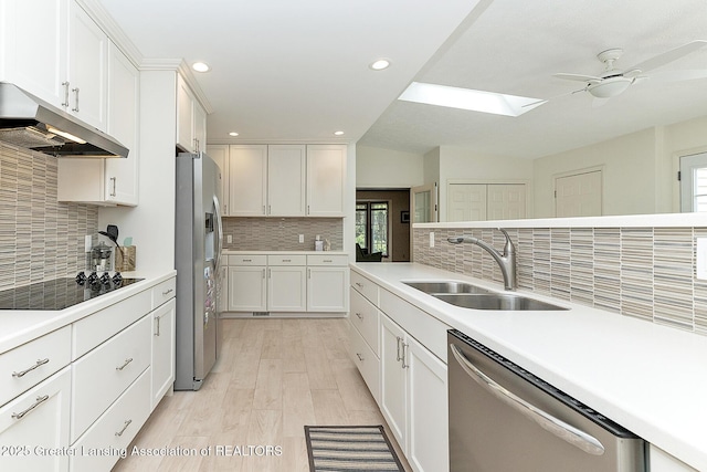 kitchen featuring a sink, stainless steel appliances, plenty of natural light, and under cabinet range hood