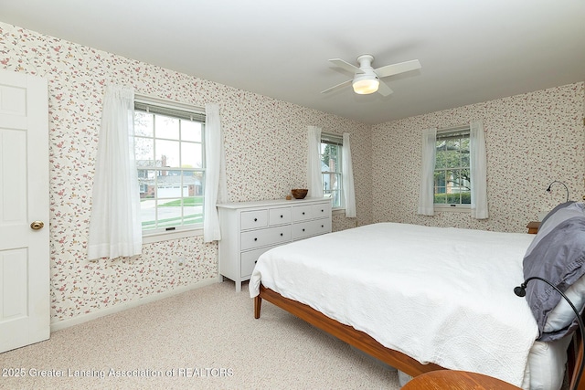 bedroom with multiple windows, carpet, a ceiling fan, and wallpapered walls