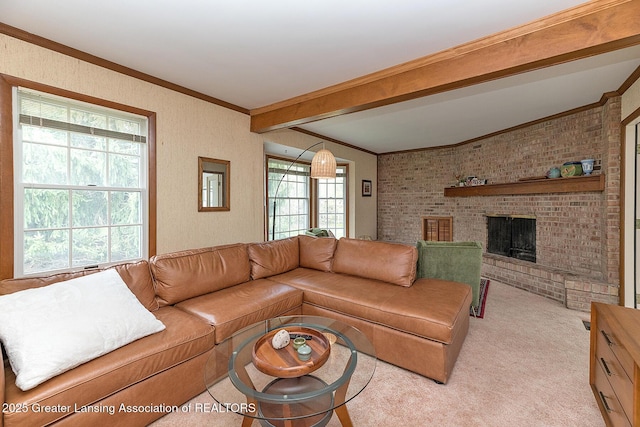 living room with ornamental molding, beamed ceiling, a brick fireplace, and light colored carpet