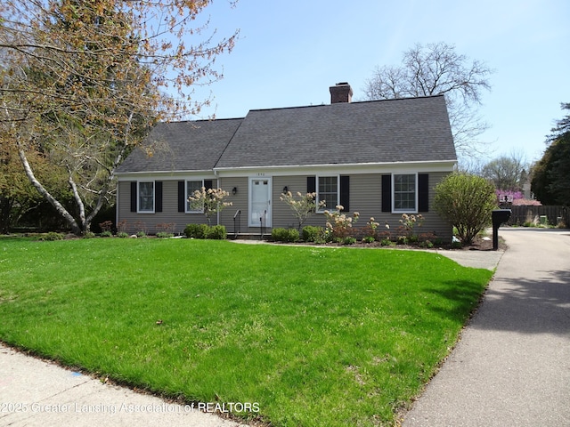 view of front of home featuring a shingled roof, a chimney, and a front yard