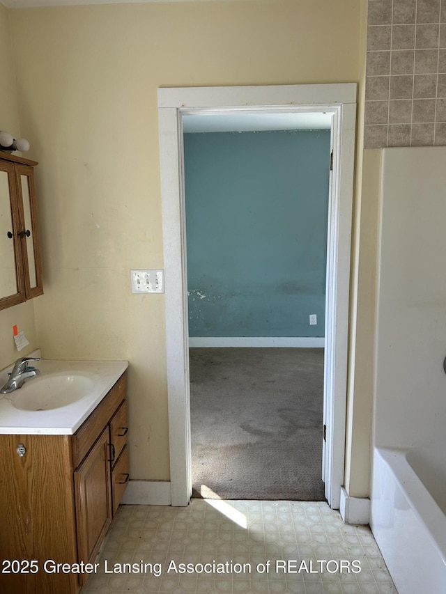 1909 W Holmes Rd, Lansing, MI 48910 - full bath with baseboards, vanity, and a bathtub