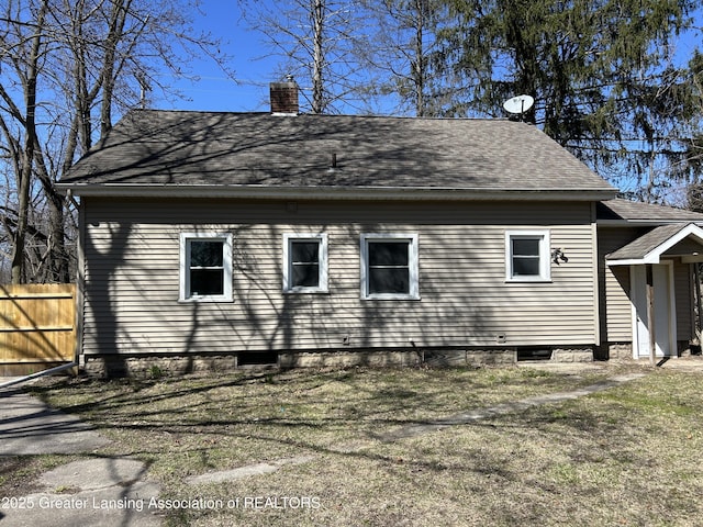 1909 W Holmes Rd, Lansing, MI 48910 - view of side of property featuring roof with shingles, a chimney, and fence