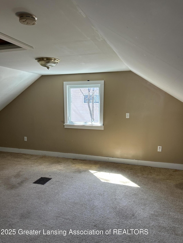 1909 W Holmes Rd, Lansing, MI 48910 - additional living space with baseboards, vaulted ceiling, visible vents, and carpet floors