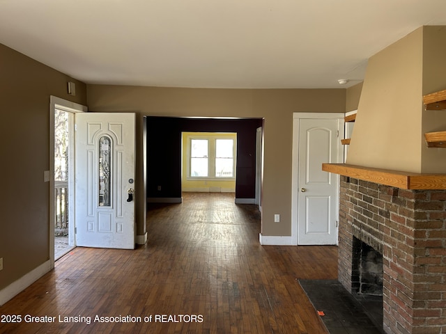 1909 W Holmes Rd, Lansing, MI 48910 - foyer entrance featuring baseboards, a brick fireplace, and dark wood-type flooring