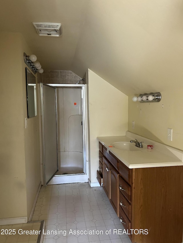 1909 W Holmes Rd, Lansing, MI 48910 - full bathroom with tile patterned floors, vaulted ceiling, visible vents, a shower stall, and vanity