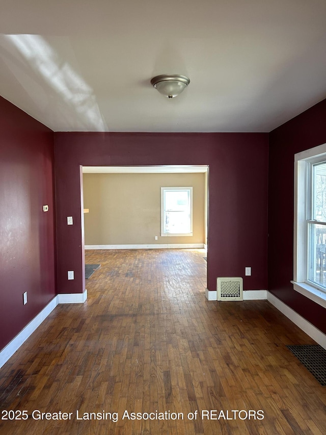 1909 W Holmes Rd, Lansing, MI 48910 - empty room featuring plenty of natural light, hardwood / wood-style flooring, and visible vents